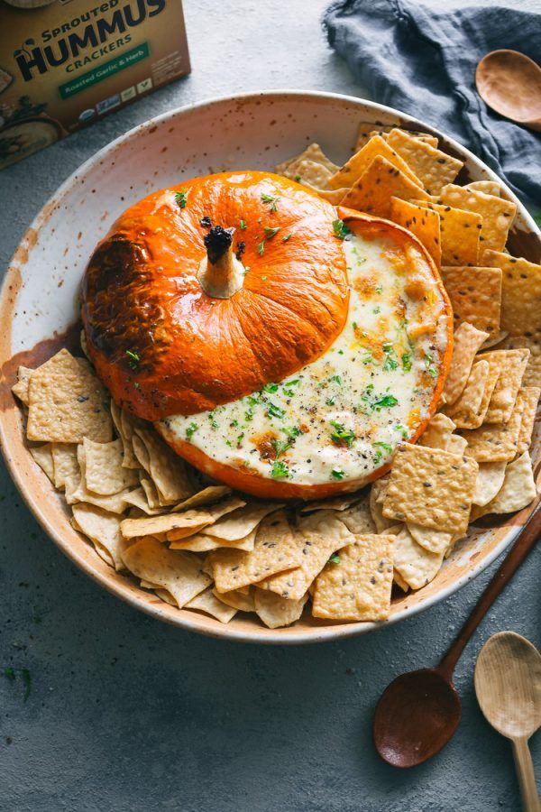 an orange sitting on top of a bowl filled with chips