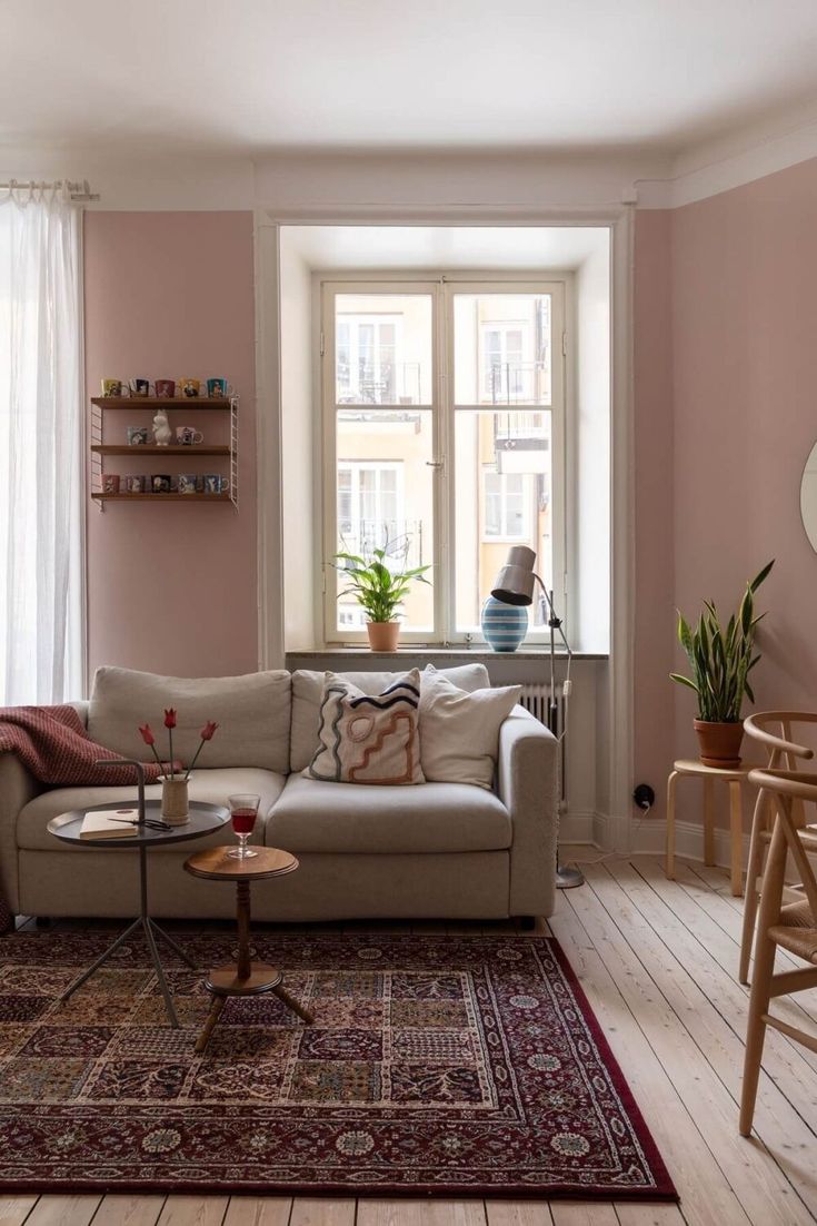 a living room filled with furniture and pink walls