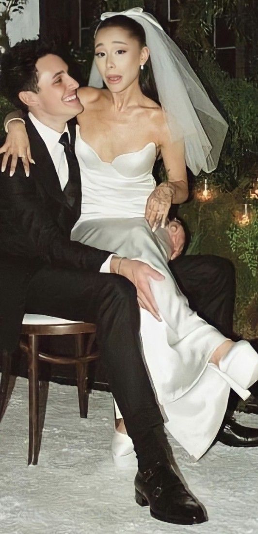 a bride and groom are sitting on a chair