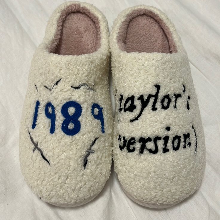 a pair of white slippers with blue writing on them