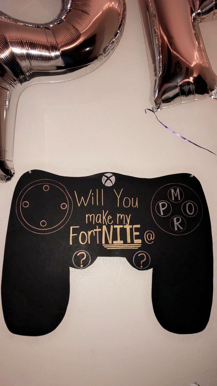 some foil balloons are laying on the floor next to a black and gold sign that says will you make my fortnite?