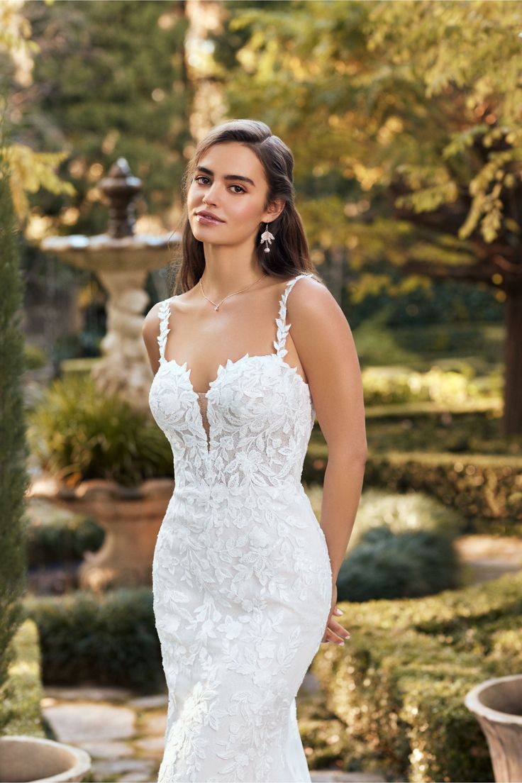 a woman in a wedding dress posing for the camera with her hands on her hips