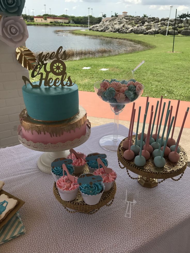 a table topped with cakes and cupcakes on top of a white table cloth