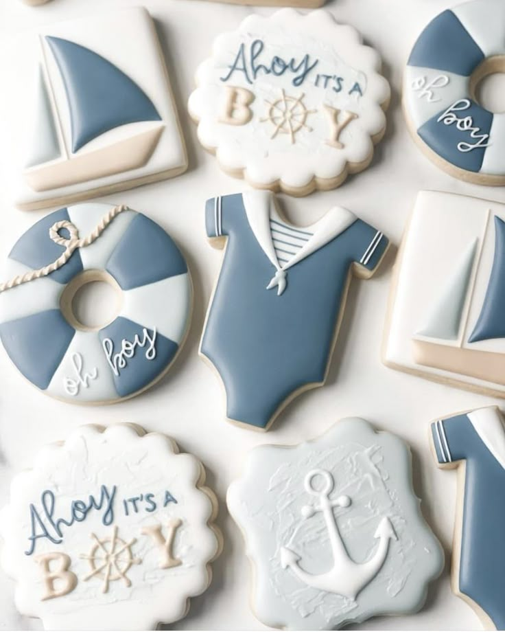 baby shower cookies decorated with blue and white icing are arranged on a table top