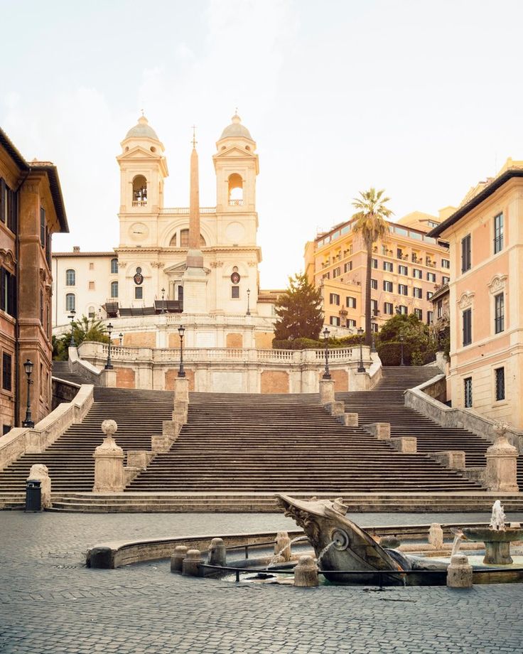 an old building with steps leading up to it in front of some buildings and stairs