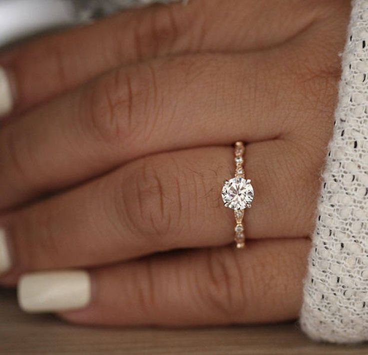 a woman's hand with a diamond ring on it