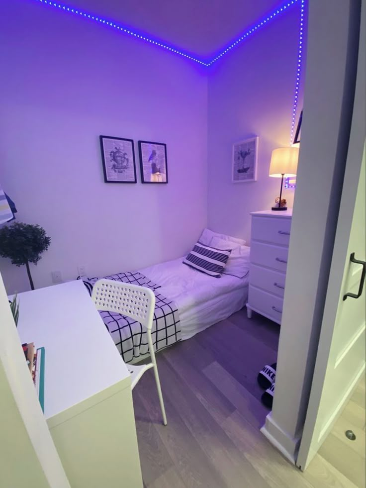 a bedroom with purple lighting and white furniture