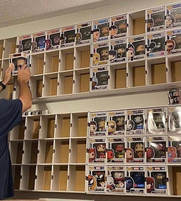 a man is taking pictures in front of some shelves