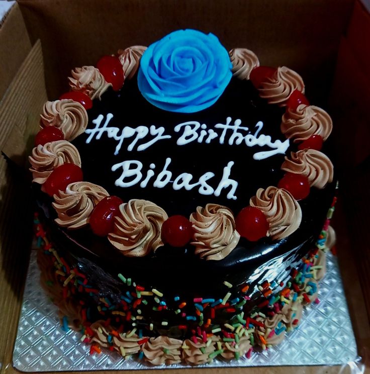 a birthday cake with chocolate frosting and sprinkles in a cardboard box