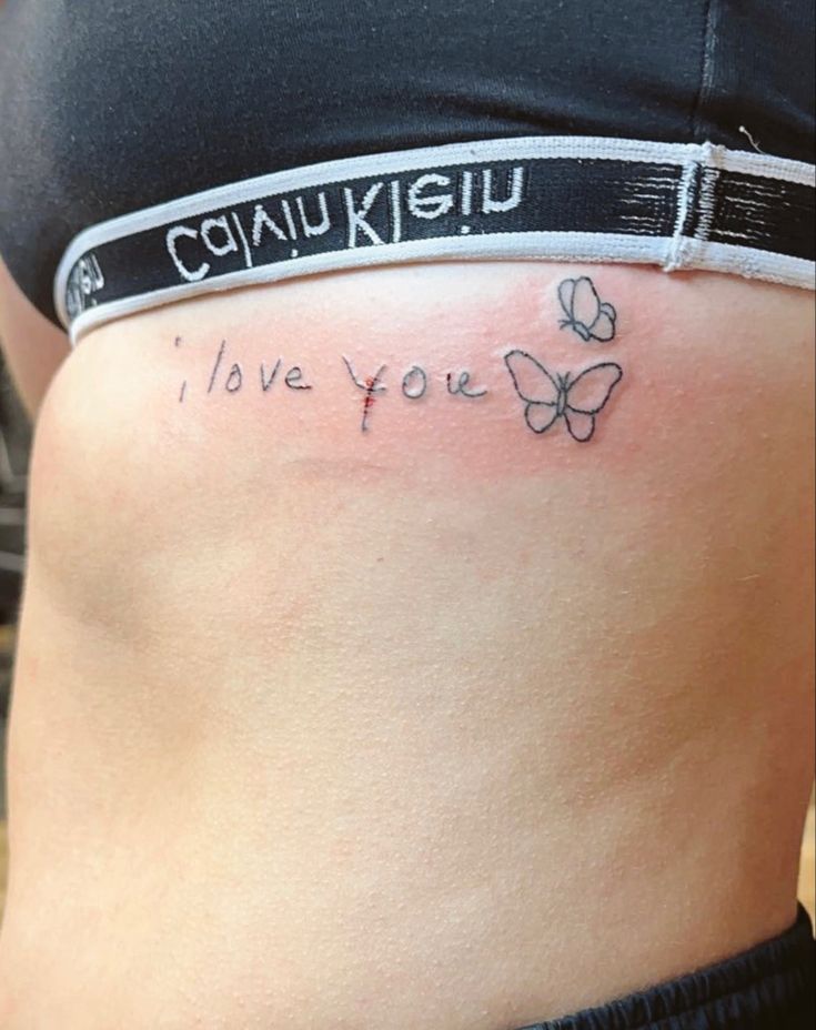 a woman's stomach with the words i love you written on it and butterflies