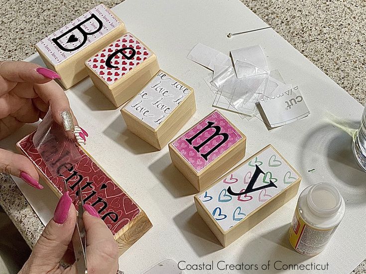 two hands are making wooden blocks that spell out the word love