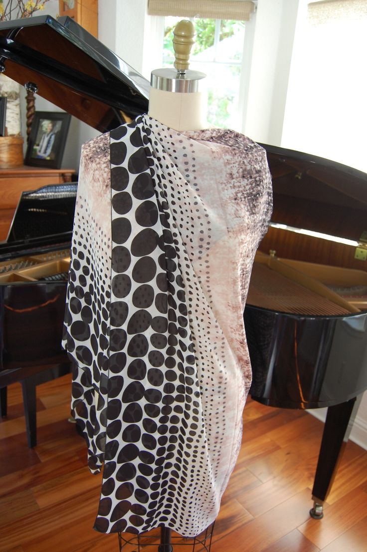 a dress on a mannequin in front of a black and white grand piano