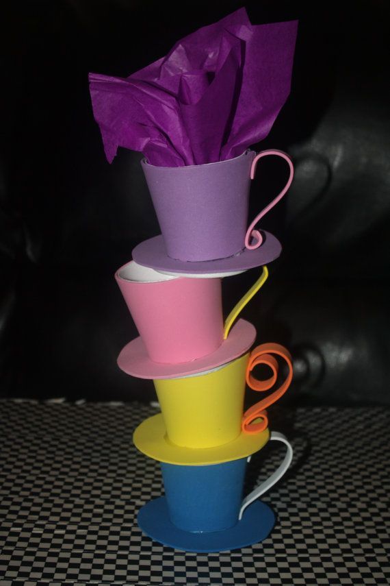 there are many cups stacked on top of each other and one has a purple umbrella