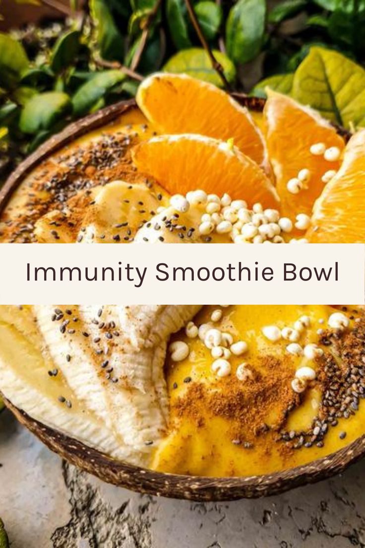 a bowl filled with bananas and oranges on top of a marble counter next to green leaves