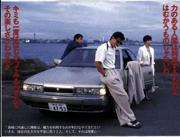 two men leaning on the hood of a car with another man standing next to it