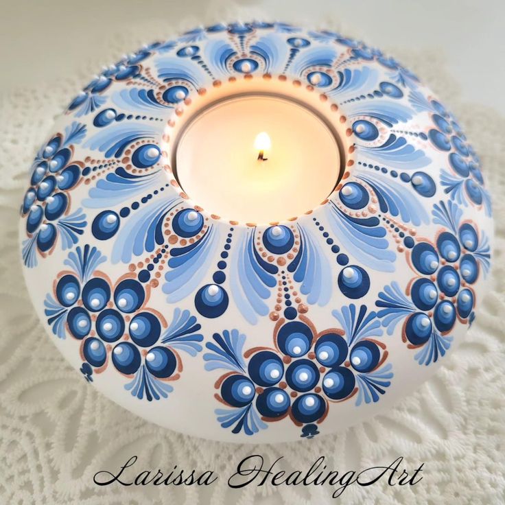 a blue and white candle holder sitting on top of a doily