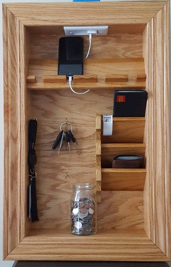 a wooden case with keys and other items in it that is attached to the wall