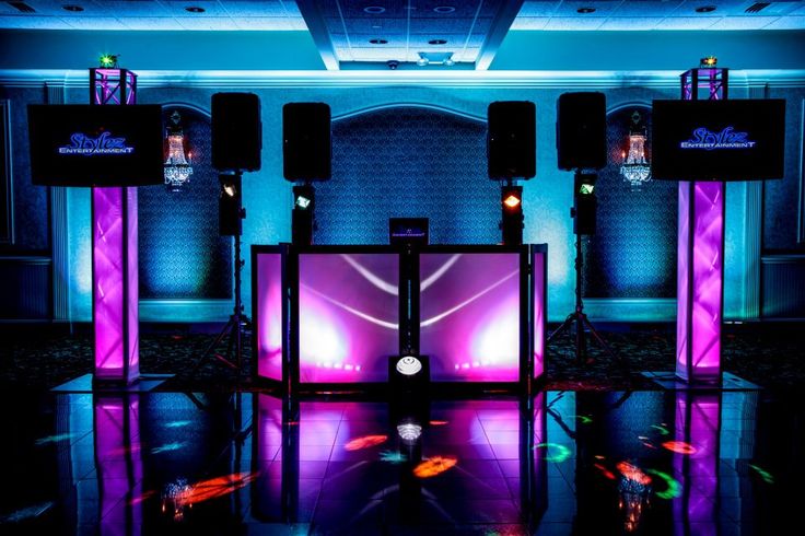 an empty stage set up for a party with purple lighting and speakers on the side