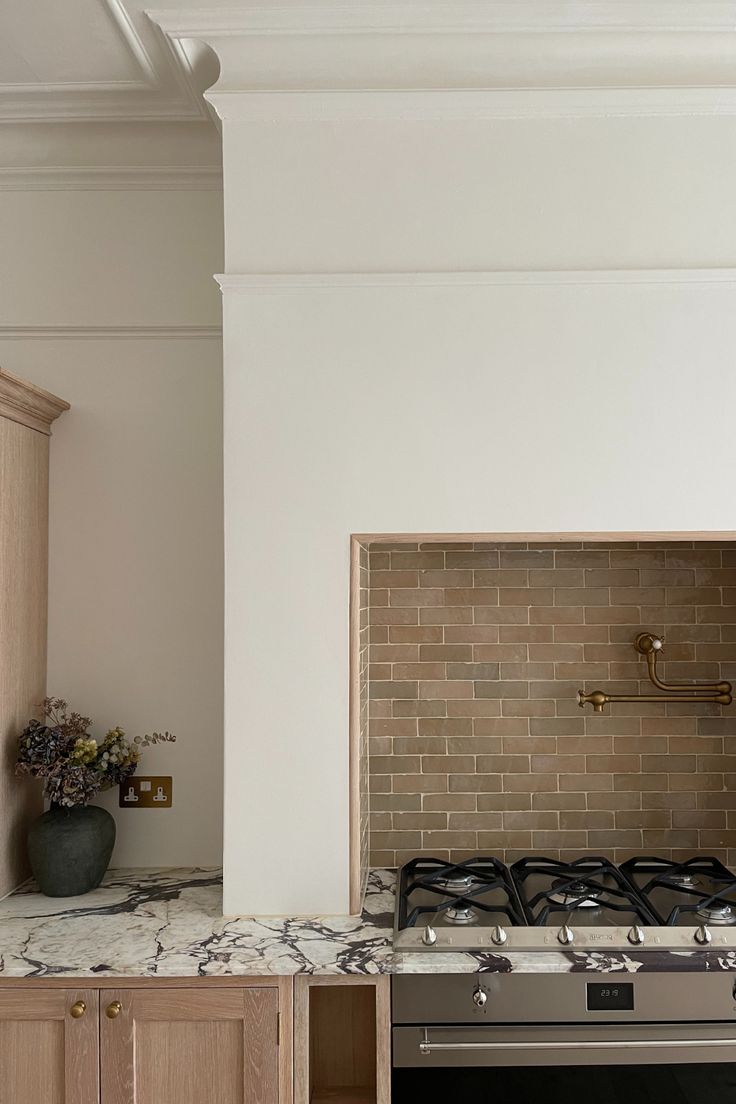 a stove top oven sitting inside of a kitchen next to wooden cupboards and cabinets