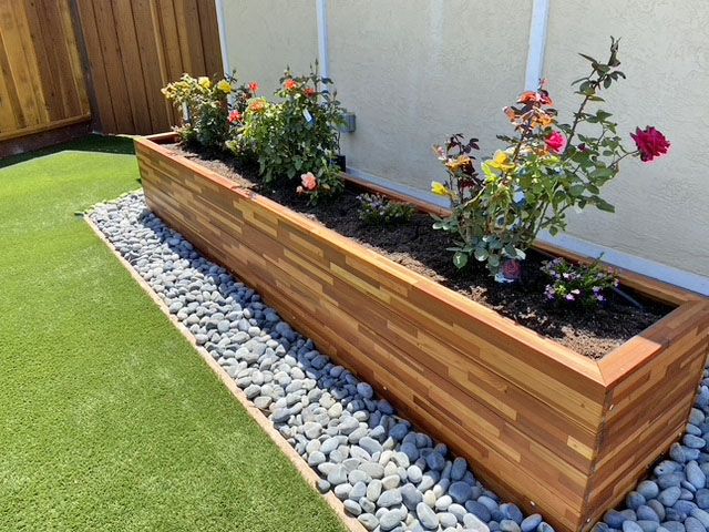 a wooden planter filled with lots of flowers