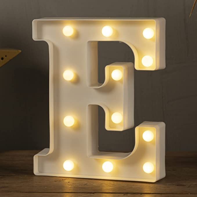 a white light up letter with lights on it's sides and an image of the letter e