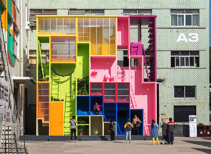 people are standing in front of a multi - colored building