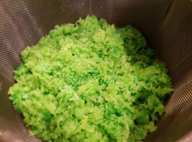 green rice in a strainer bowl ready to be cooked or put into the oven