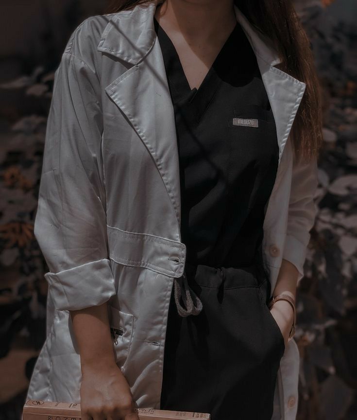 a woman in black shirt and white jacket holding a brown box with her hand on it