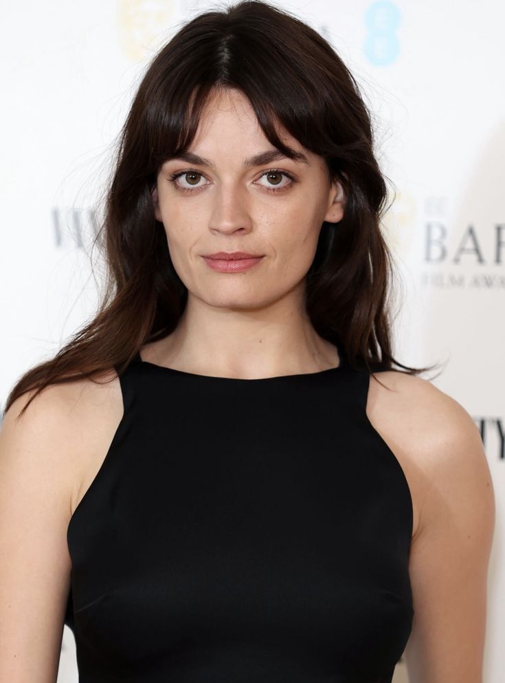 a woman in a black dress posing for the camera