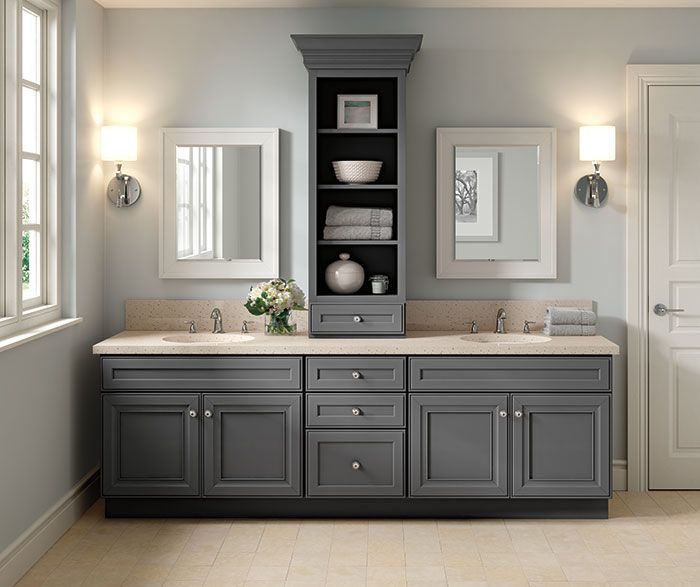 a bathroom with double sinks and gray cabinets