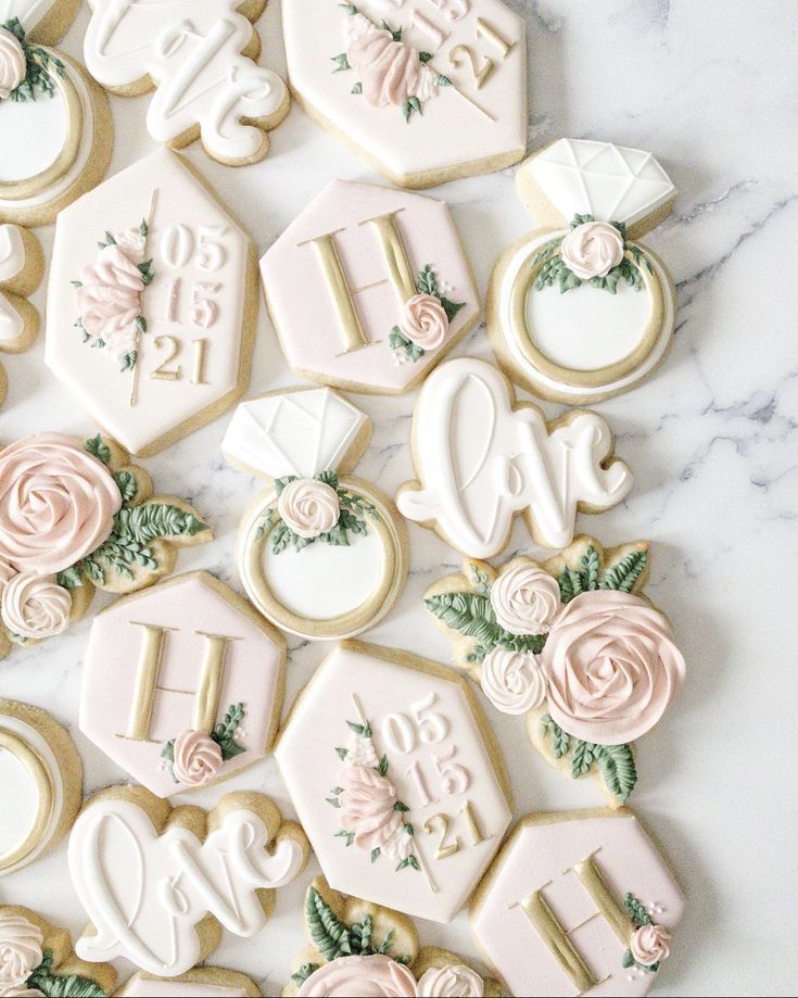 decorated cookies are arranged in the shape of letters and numbers on a marble countertop