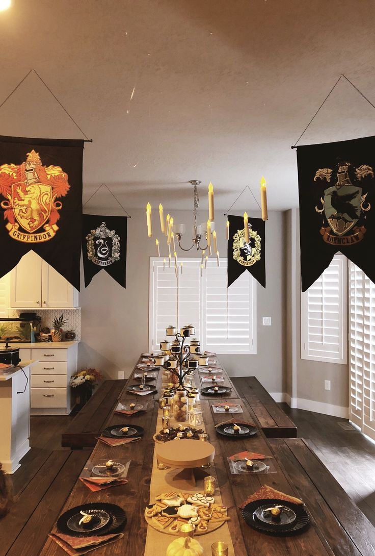 a long dining table with harry potter flags hanging from it's sides and place settings on the tables