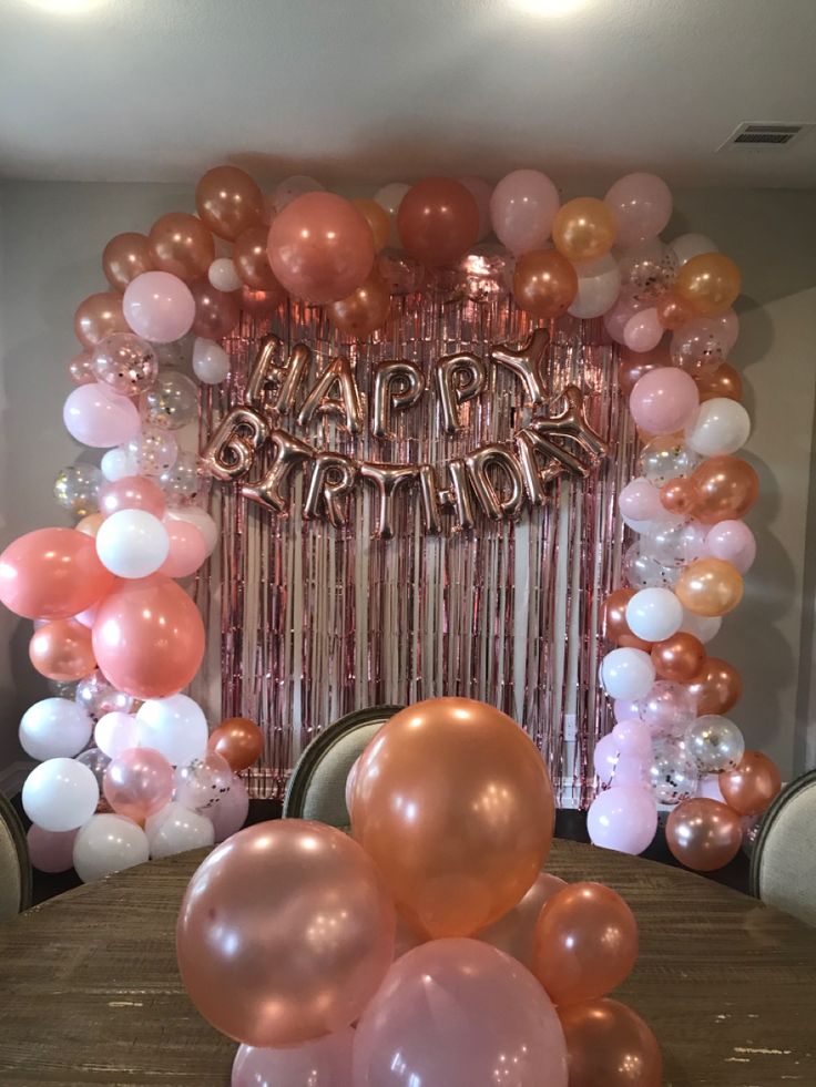 balloons and streamers are on the table in front of a happy birthday sign that reads,