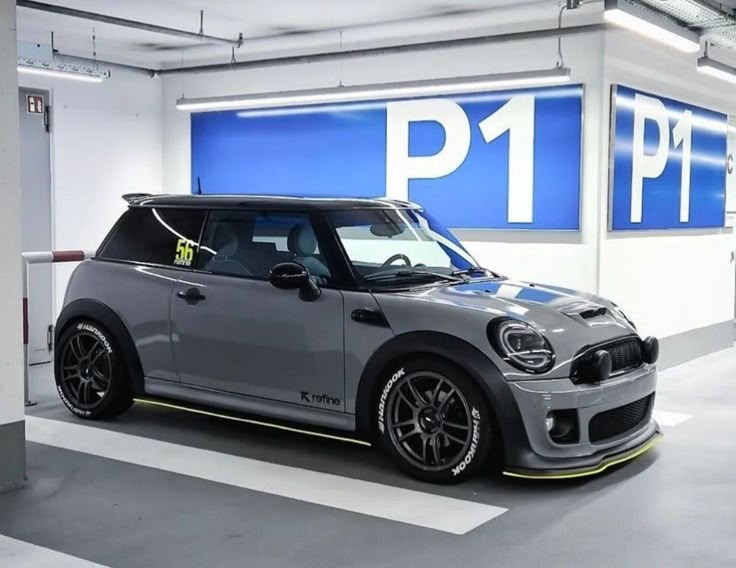 a grey mini cooper parked in a parking garage