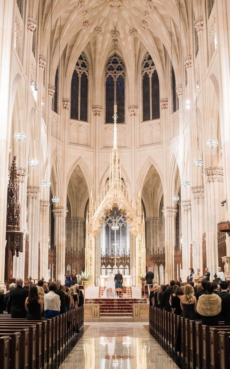 the inside of a church with pews and people sitting at the alter looking on