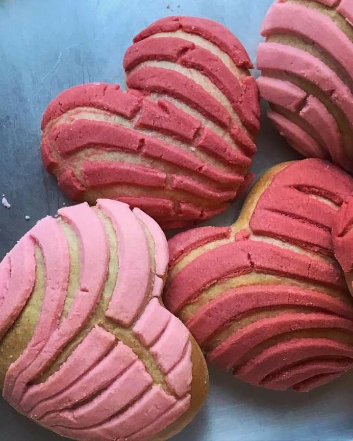 some pink and yellow cookies are on a blue plate