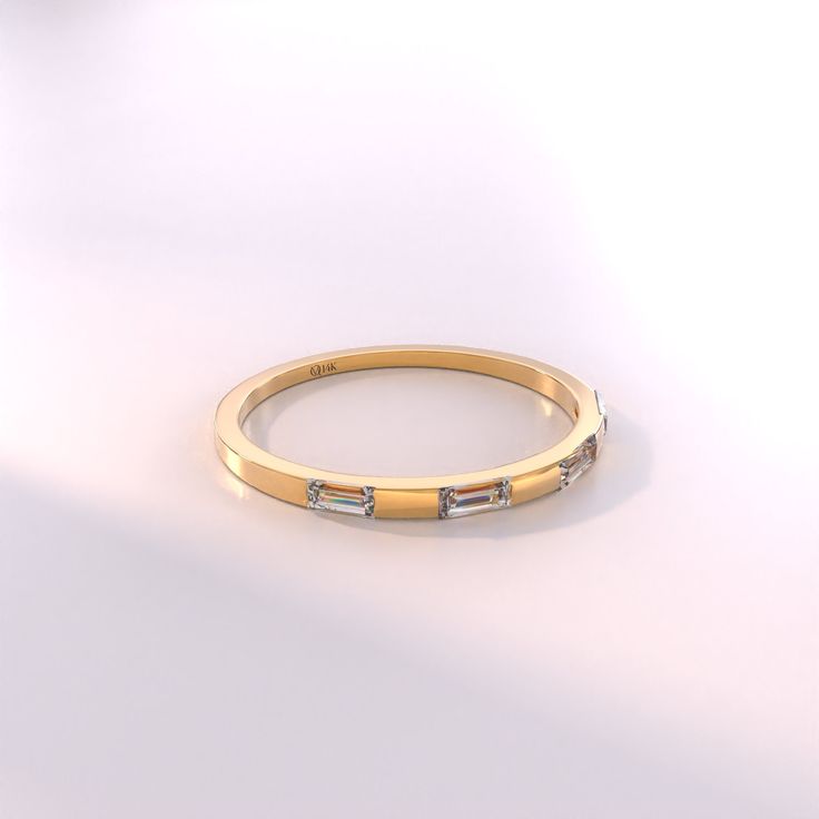 a yellow gold ring with three baguettes on the side and two diamonds in the middle