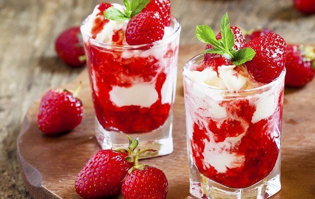 two glasses filled with ice cream and strawberries