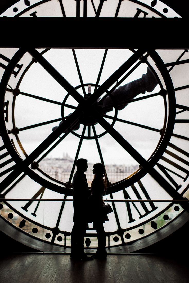 a person standing in front of a large clock