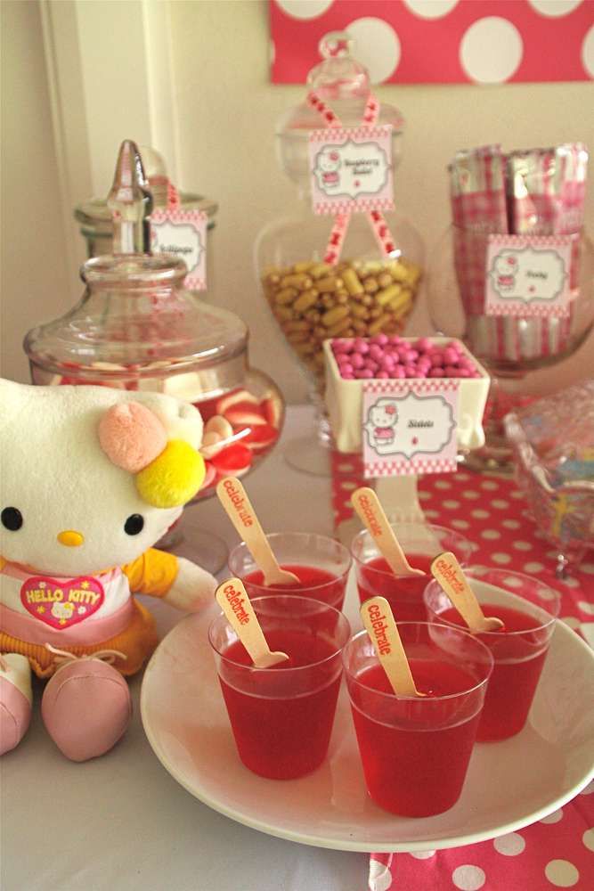 a hello kitty themed birthday party with candy and candies on the table, including cupcakes