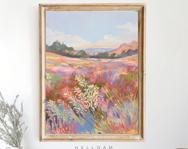 a painting hanging on the wall next to a vase with flowers in front of it