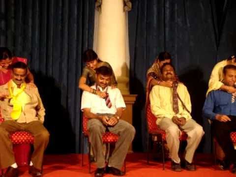 several people sitting on chairs in front of a curtain