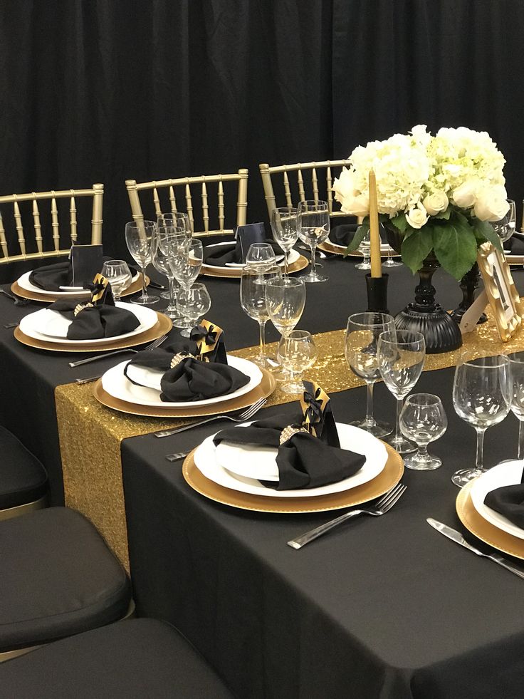 a table set with black and gold place settings