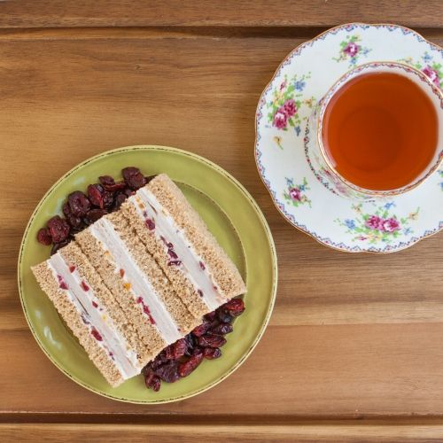 a piece of cake sitting on top of a plate next to a cup of tea