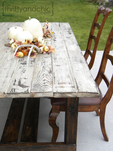 an old wooden table with chairs around it and some pumpkins on the table top