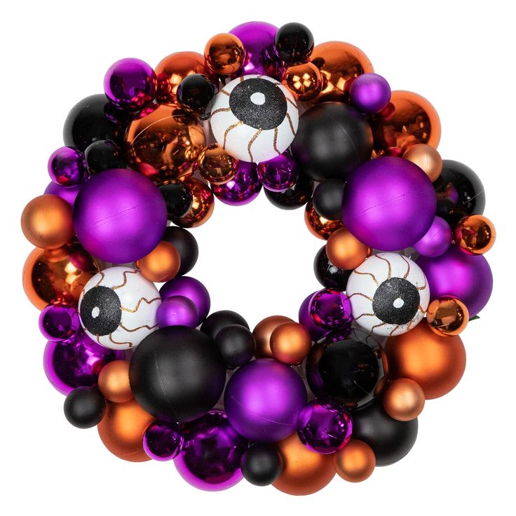 a purple and orange wreath with black, white, and gold ornaments in the center