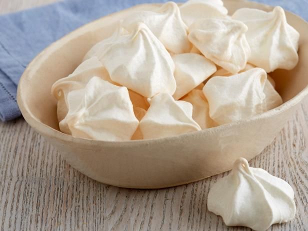 a bowl filled with white meringue next to a blue towel