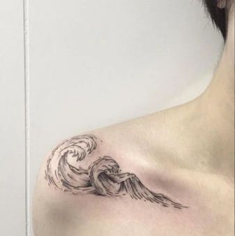 a woman's chest with a wave tattoo on it