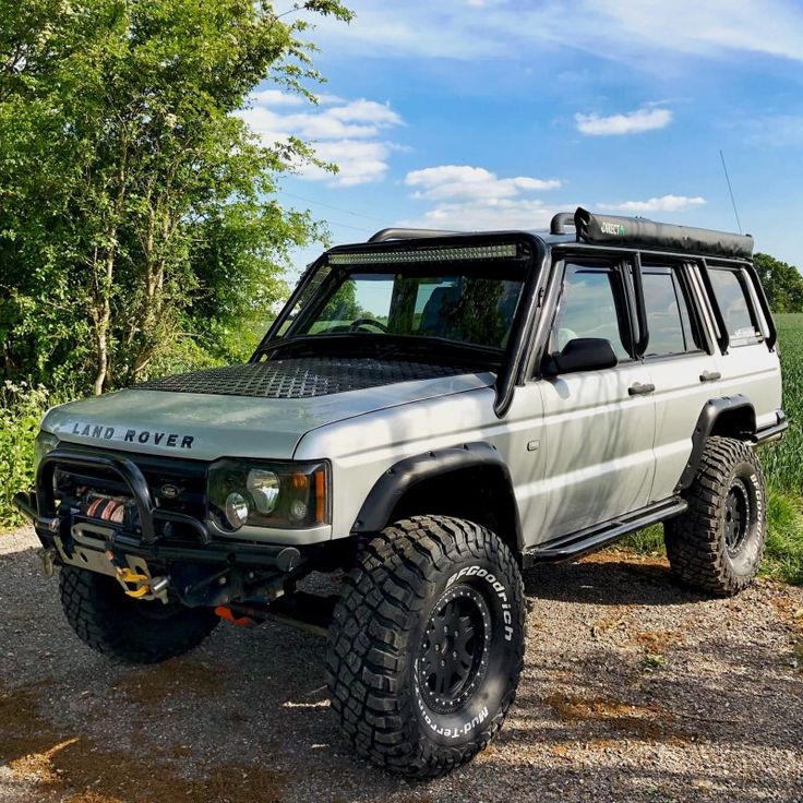 a white suv parked on top of a gravel road