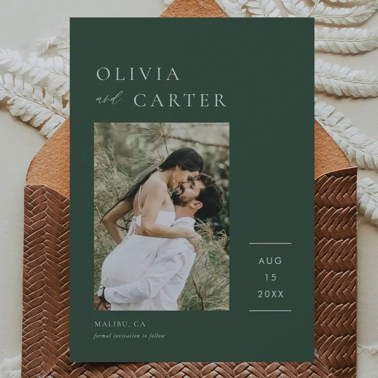 an image of a couple kissing on the cover of their wedding album, which is printed in green and white